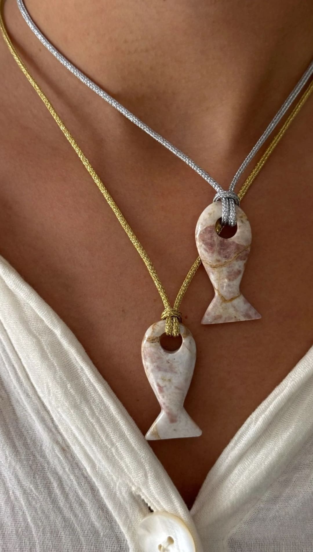 Two fish-shaped pendants on cords.
