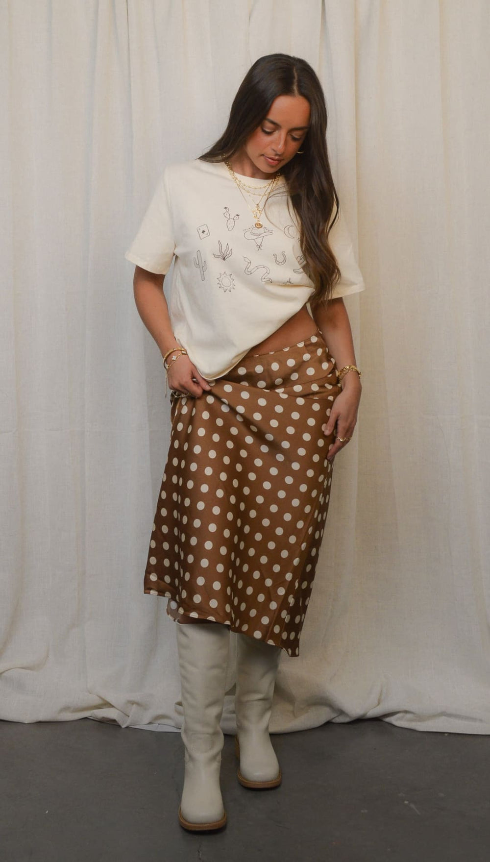 Woman in polka dot skirt and boots.