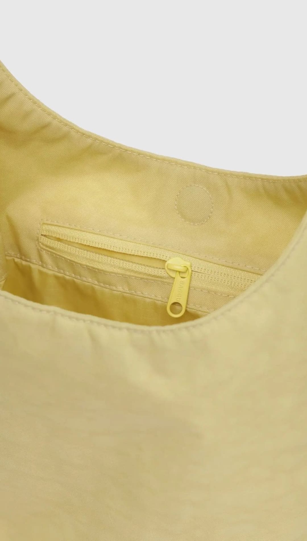 Yellow nylon shoulder bag with zipper pocket.