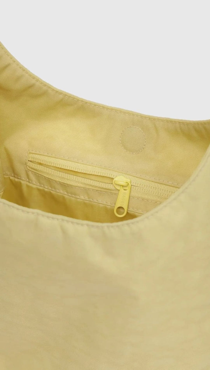 Yellow nylon shoulder bag with zipper pocket.