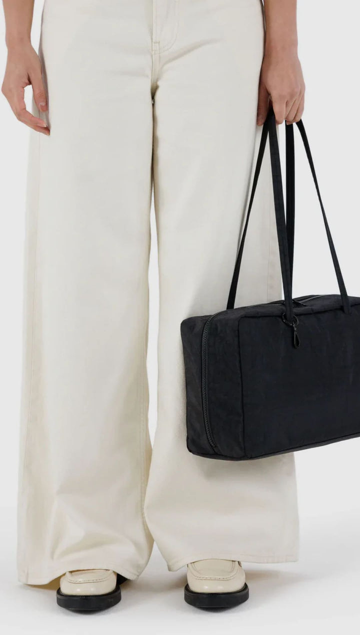 Black rectangular tote bag with long handles and structured design.