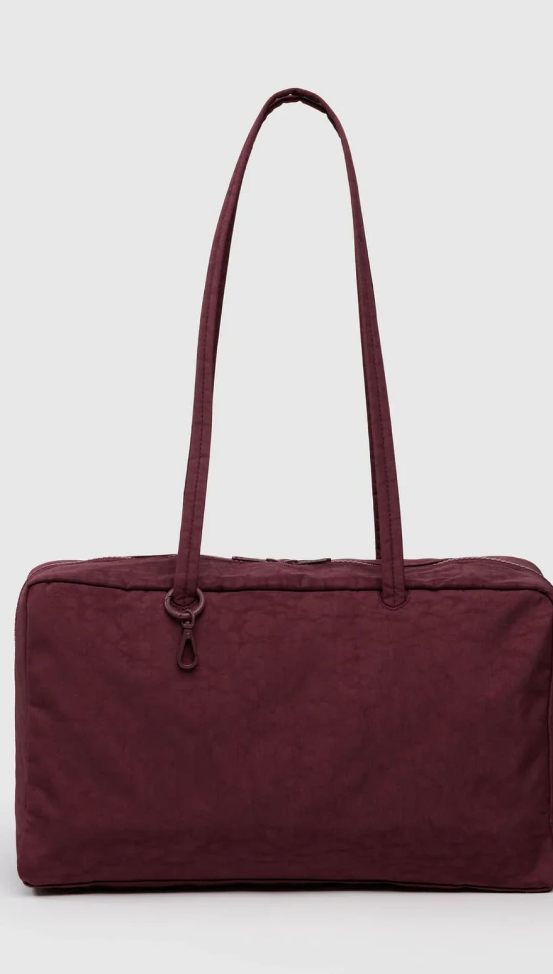 Burgundy duffel bag with black strap and zipper closure, nylon material.