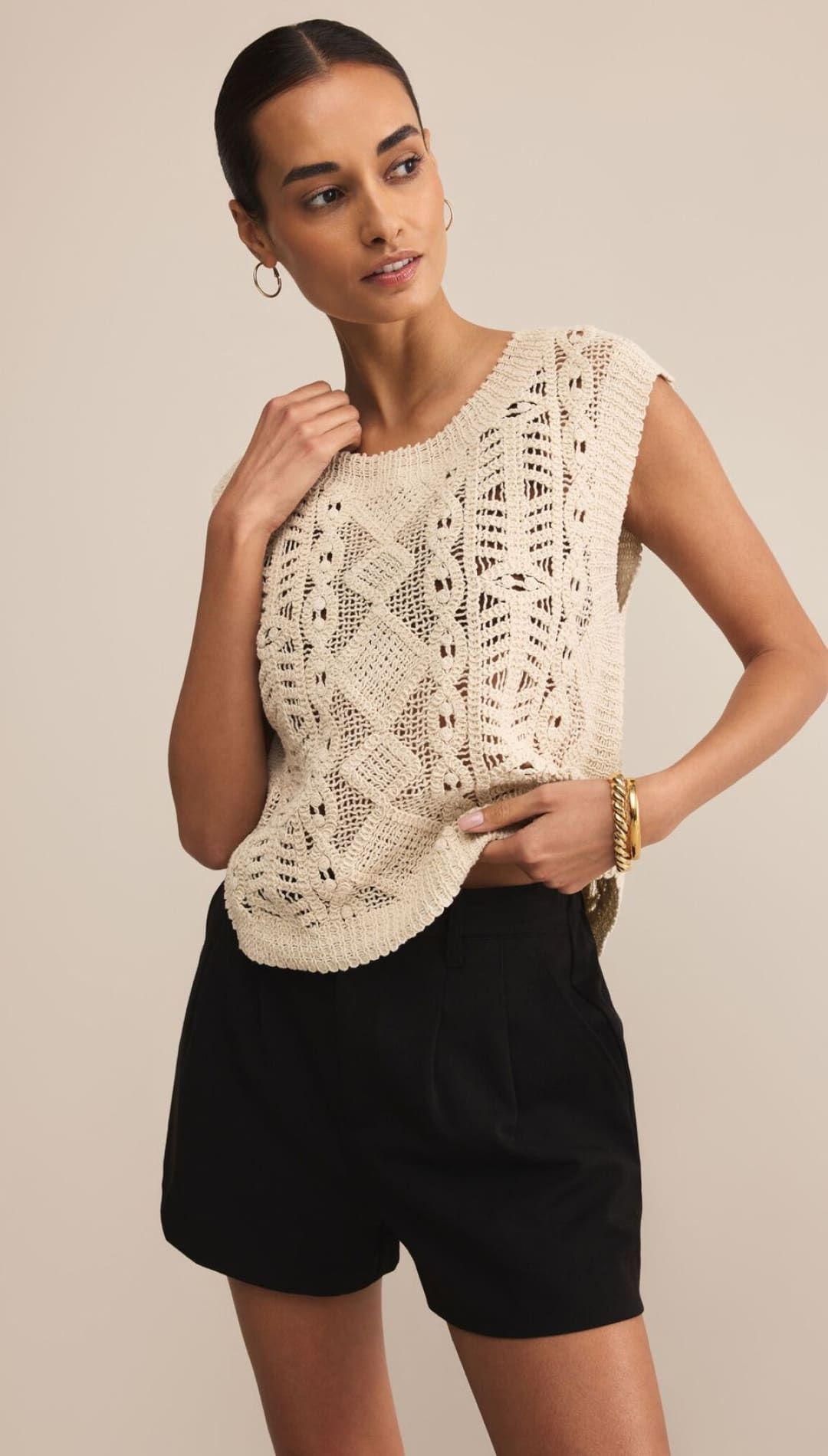 Women’s cream-colored sleeveless knit top with intricate open-work patterns.
