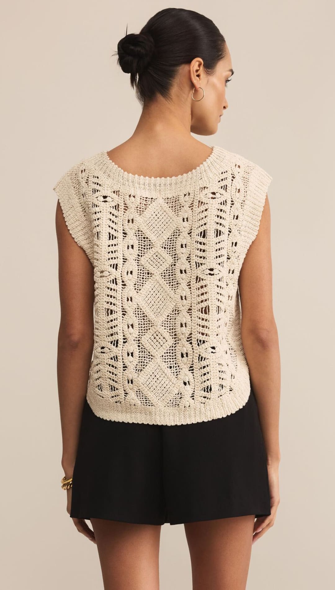 Women’s cream-colored sleeveless knit top with an intricate open-knit pattern.