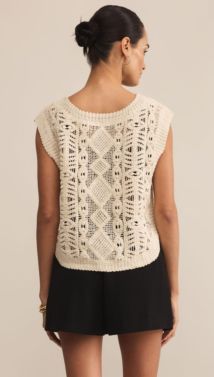 Women’s cream-colored sleeveless knit top with an intricate open-knit pattern.
