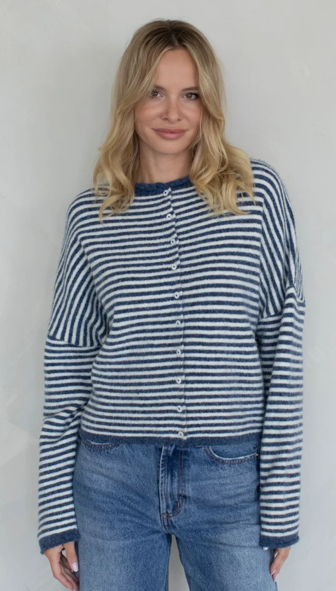 Striped cardigan sweater with buttons, navy and white color scheme.