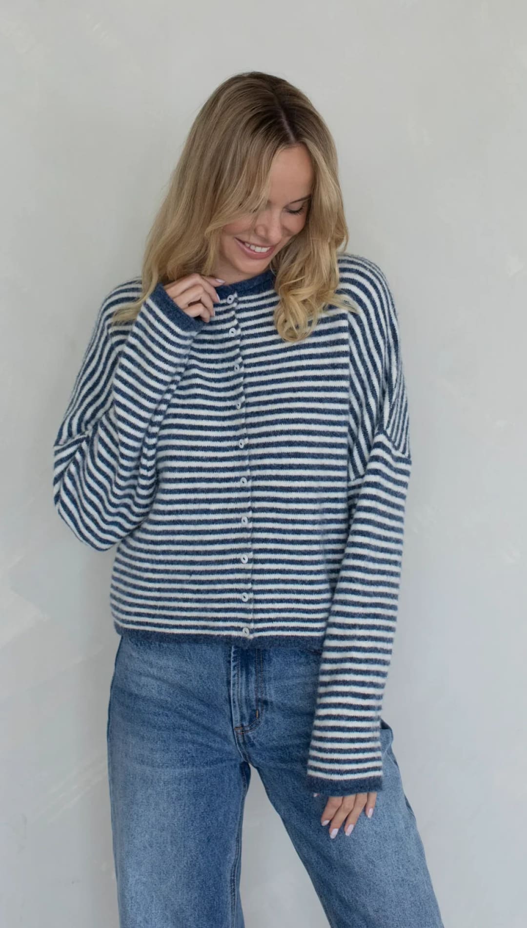 Blue and white striped cardigan sweater with long sleeves.
