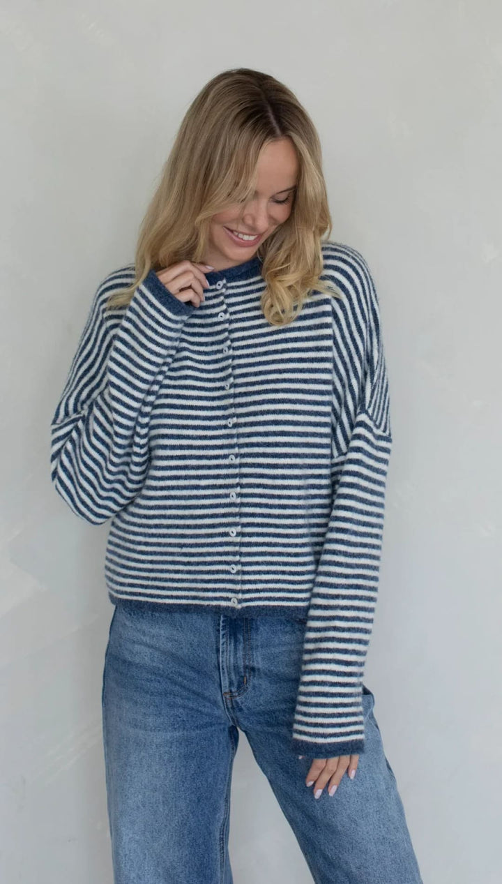 Blue and white striped cardigan sweater with long sleeves.