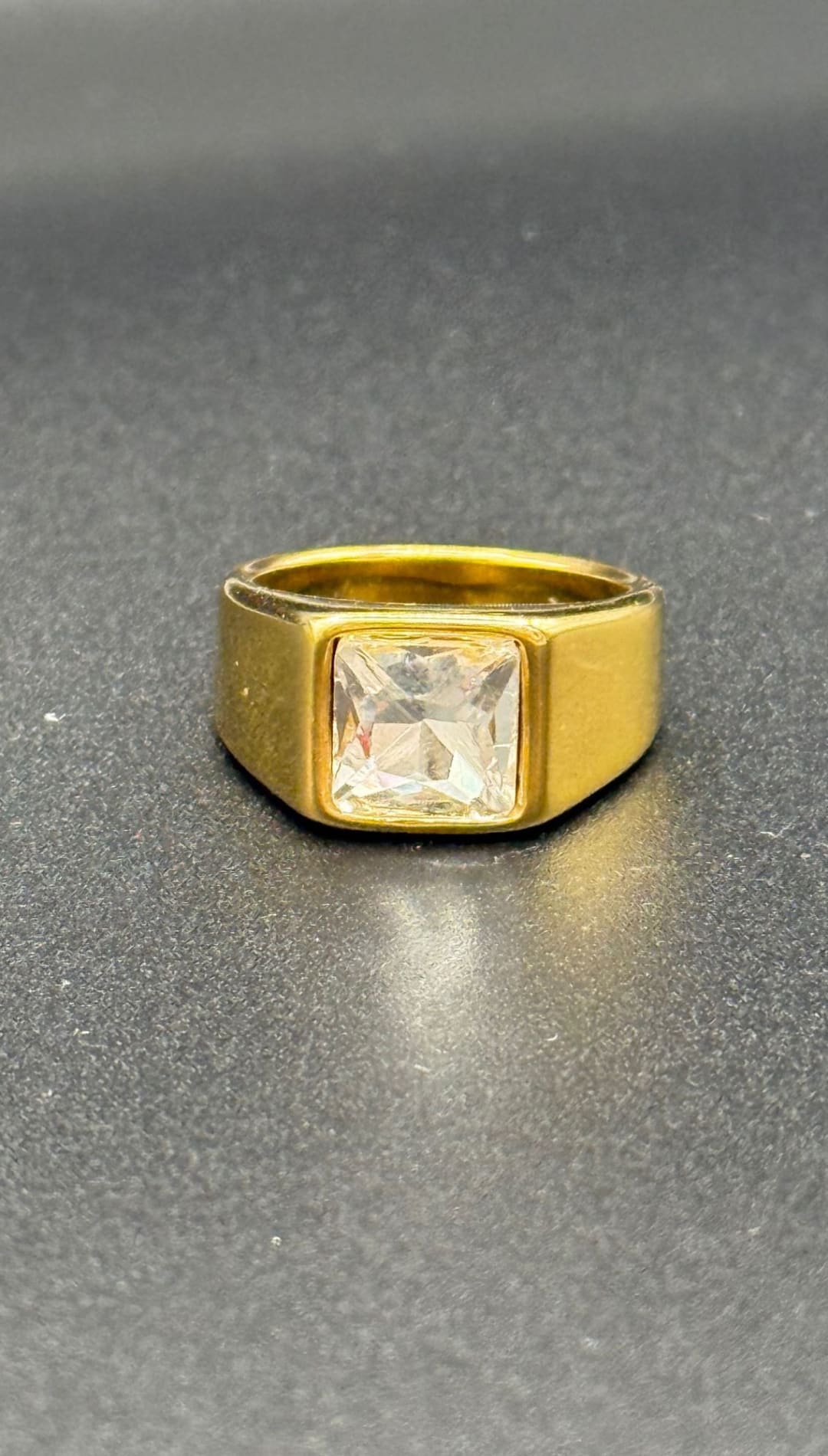 Gold ring with square gemstone.