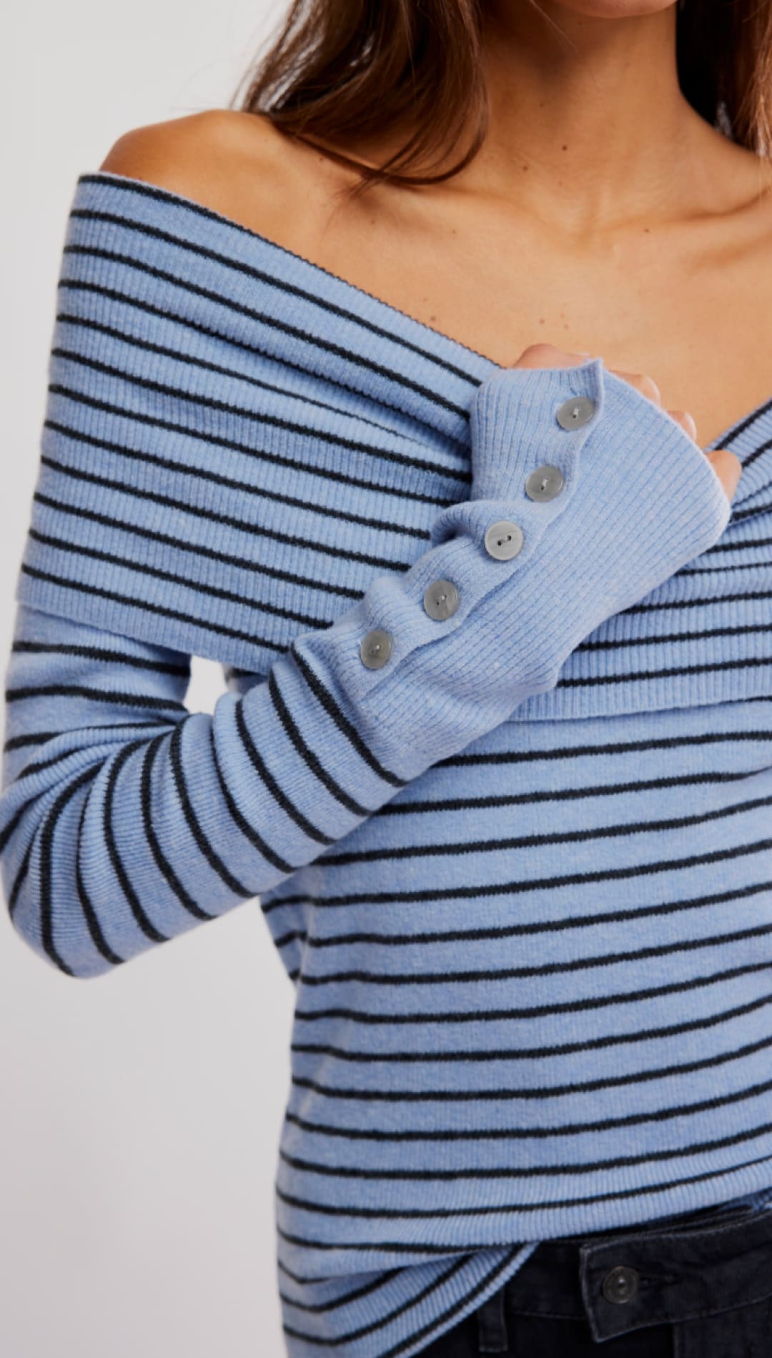 Blue striped off-the-shoulder sweater with buttoned cuffs.