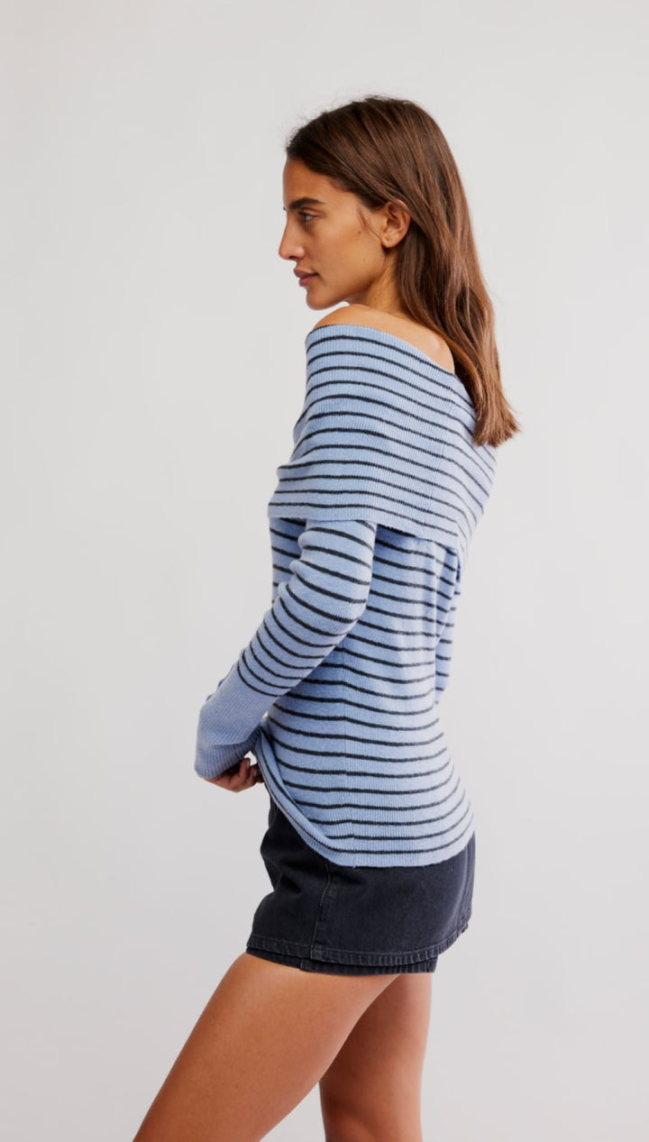 Woman wearing a blue and black striped off-the-shoulder top.