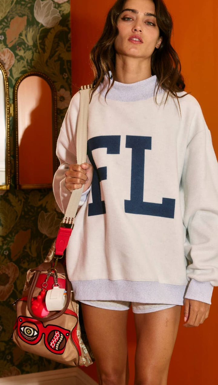 White fl sweatshirt with navy blue lettering and ribbed cuffs, collar, and hem.