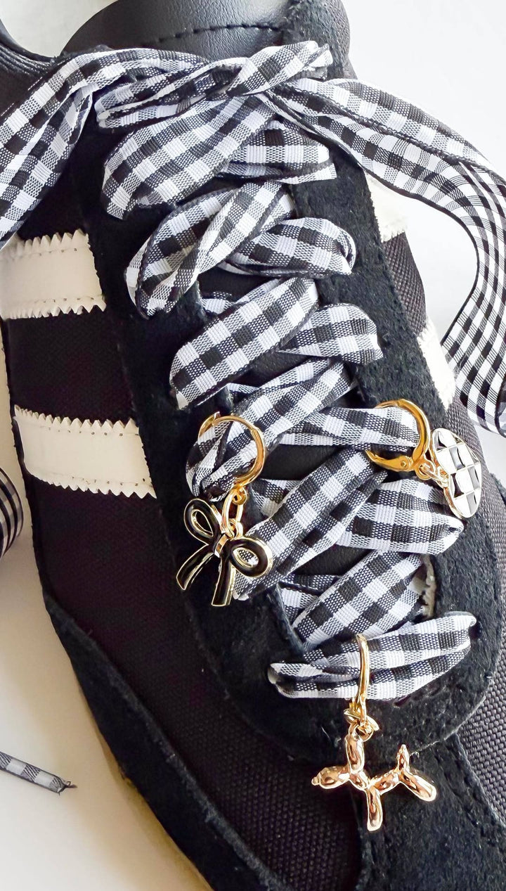 Black sneaker with gingham ribbon laces and charms.