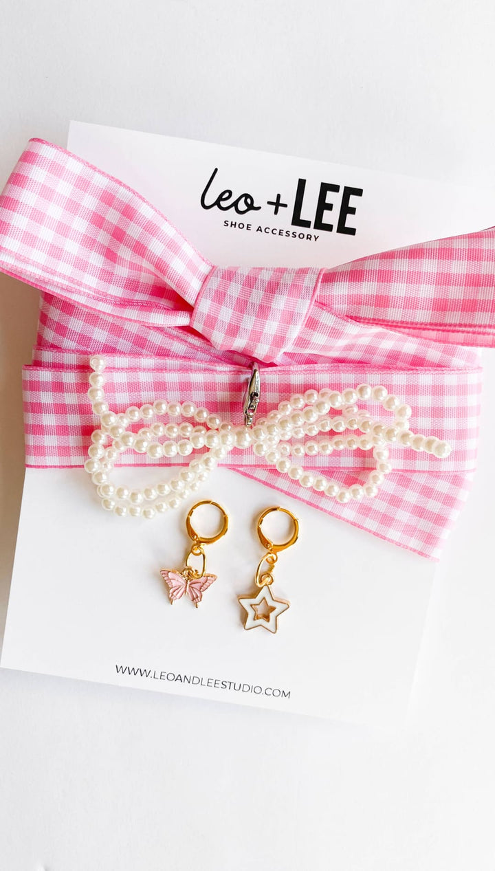 Pink gingham bow with pearl necklace and earrings.