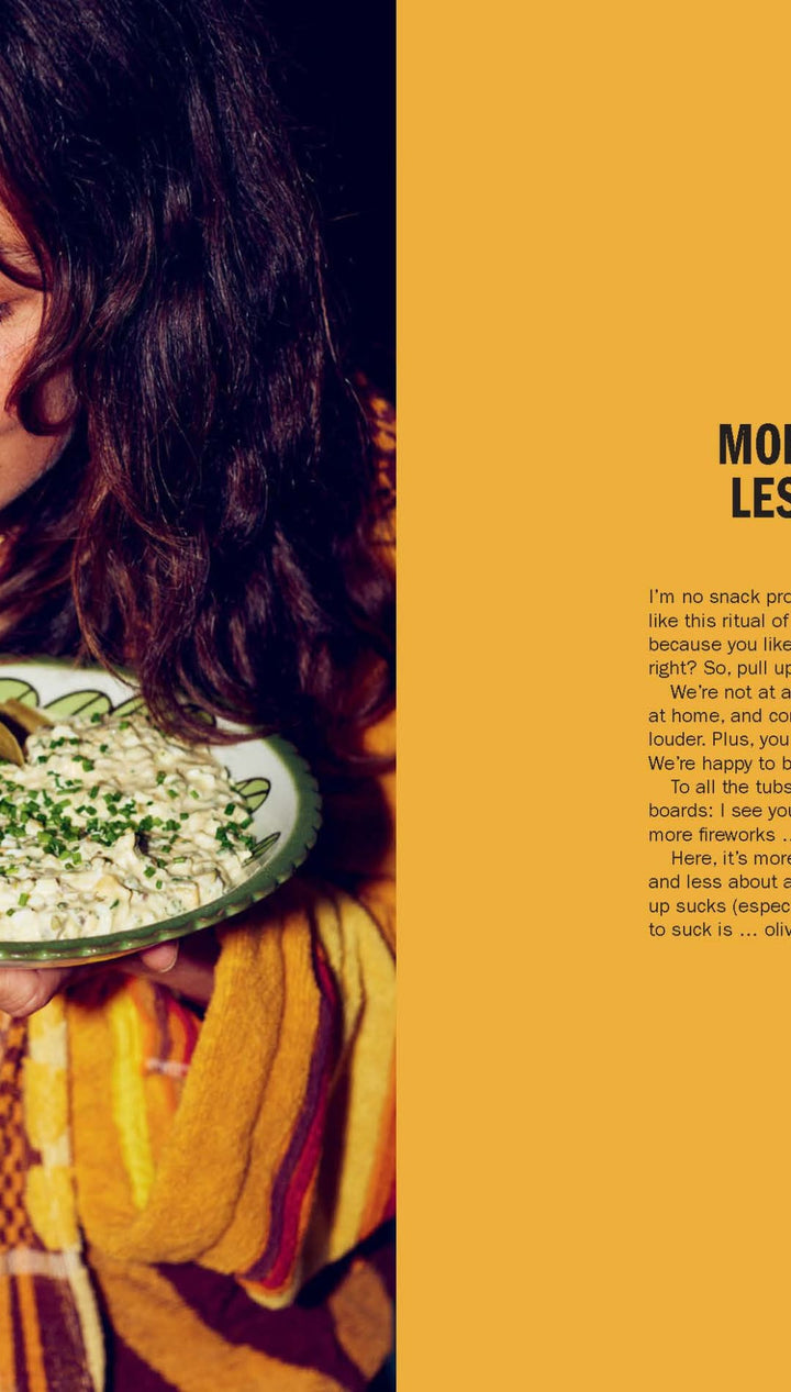 Ceramic bowl with green dip and herbs, yellow background.