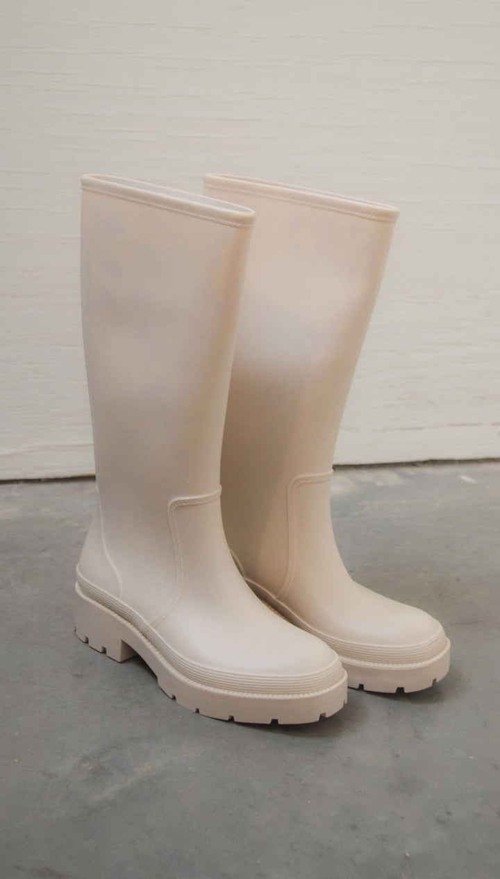 Beige rubber rain boots.