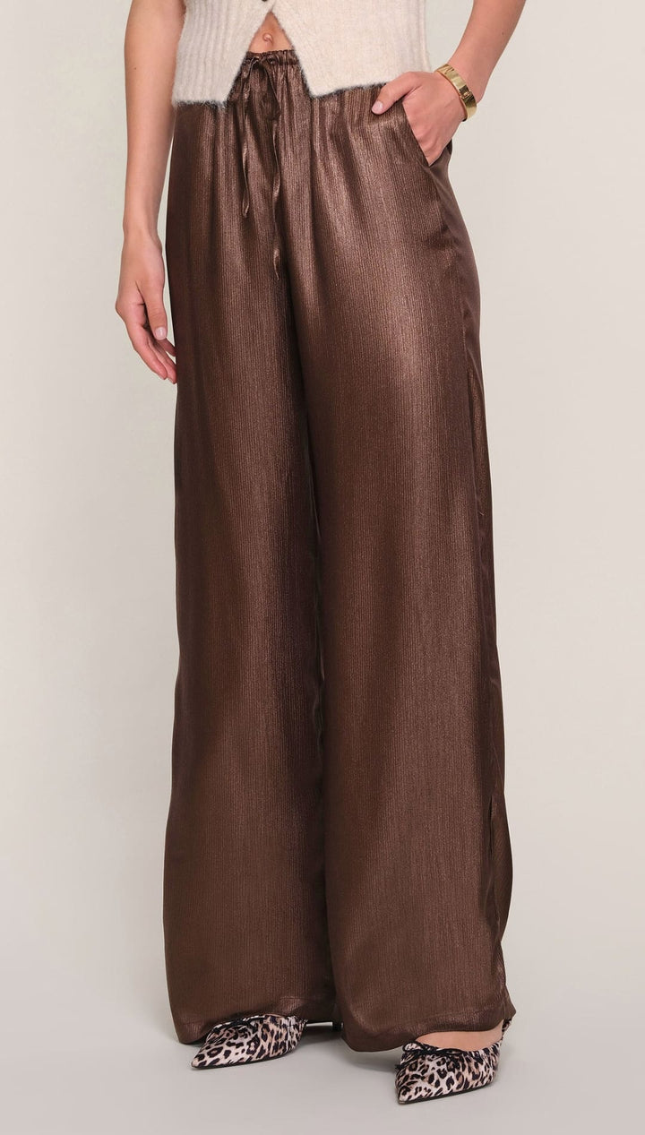 Brown satin wide-leg pants with pockets and a high waistband.