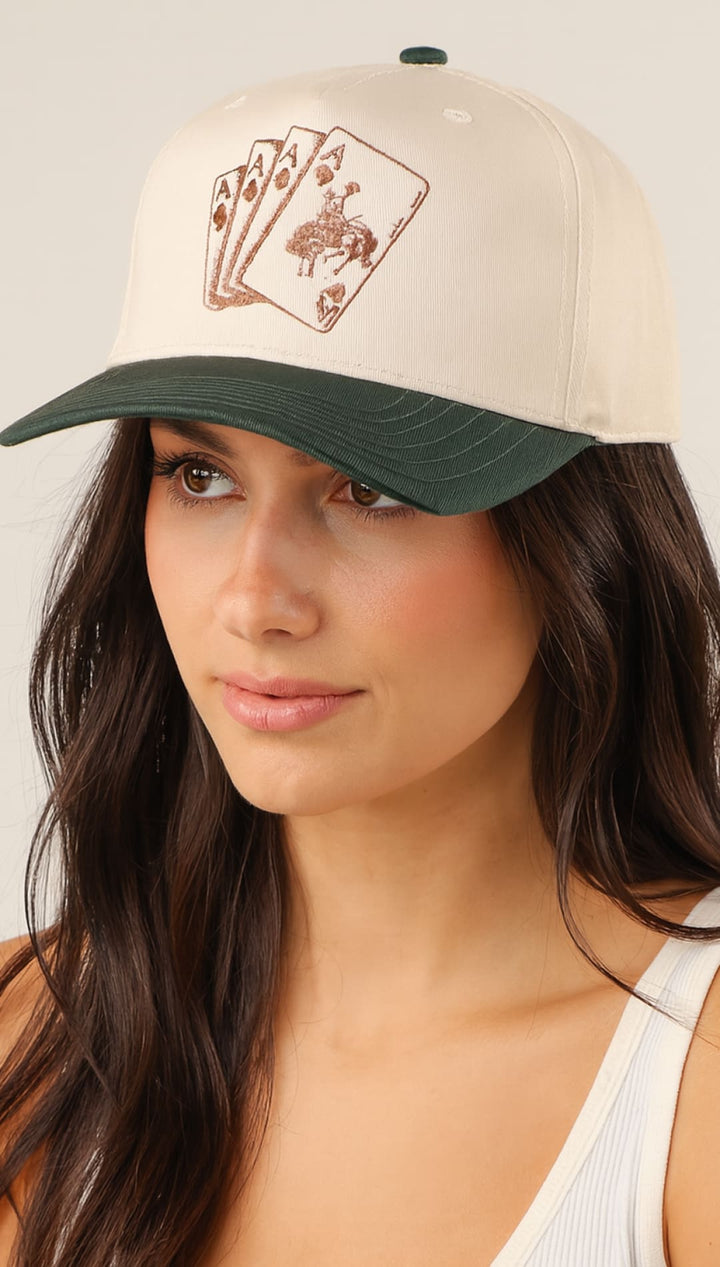 White and green baseball cap with playing card design, likely cotton or polyester blend.