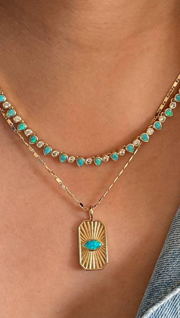 Layered gold necklaces with turquoise accents.