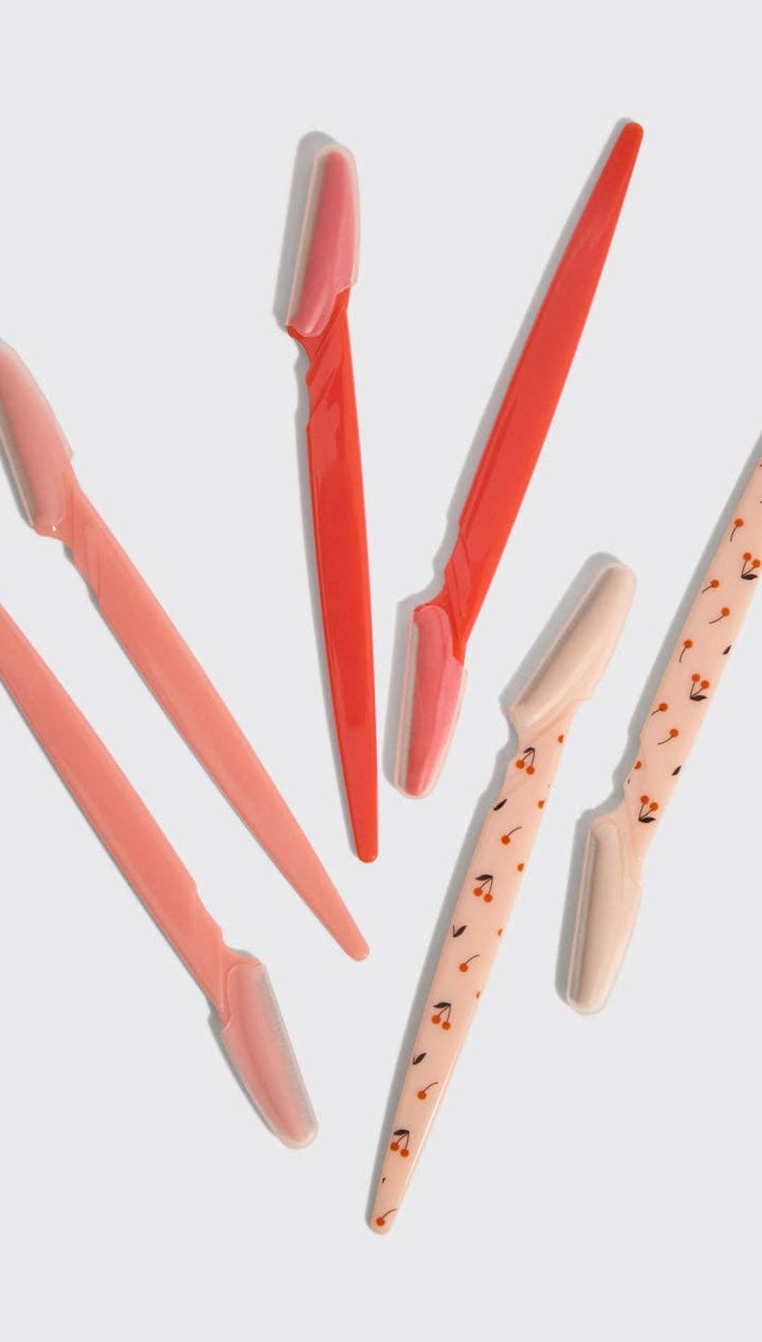 Coral and white toothbrushes with floral pattern on handles.