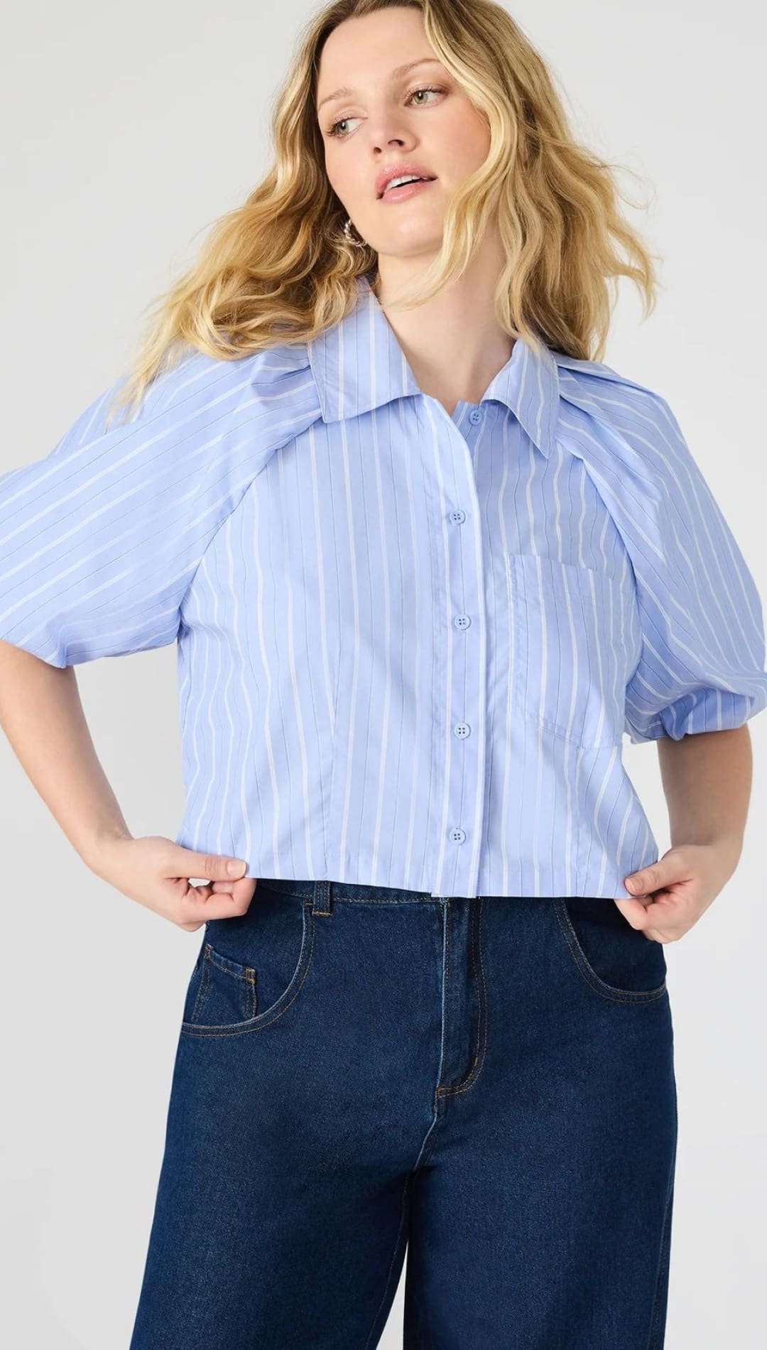 Woman in a striped, short-sleeved blouse and dark jeans.