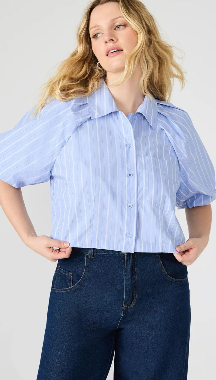 Woman in a striped, short-sleeved blouse and dark jeans.