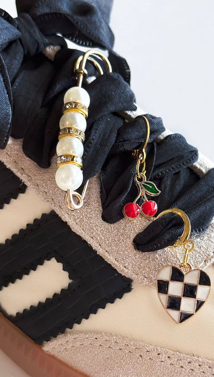 Decorated sneaker with black ribbon laces.