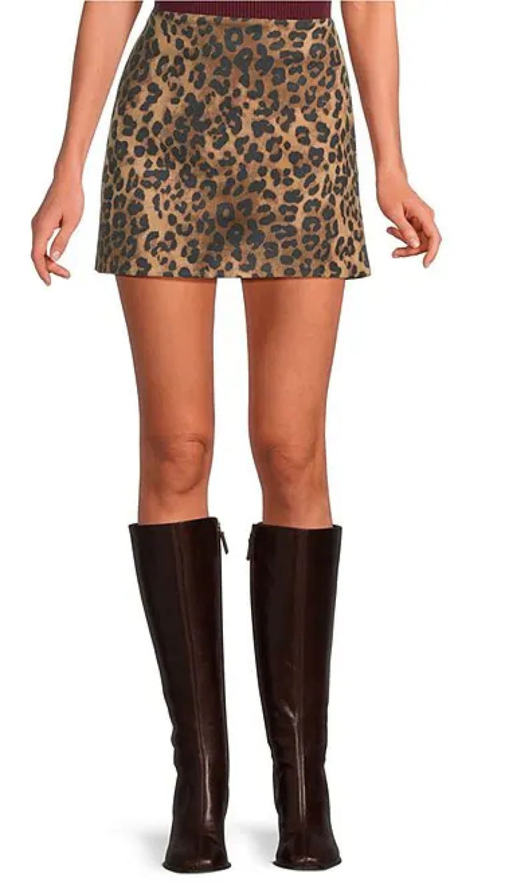 Leopard print mini skirt with a red waistband and tall brown boots.