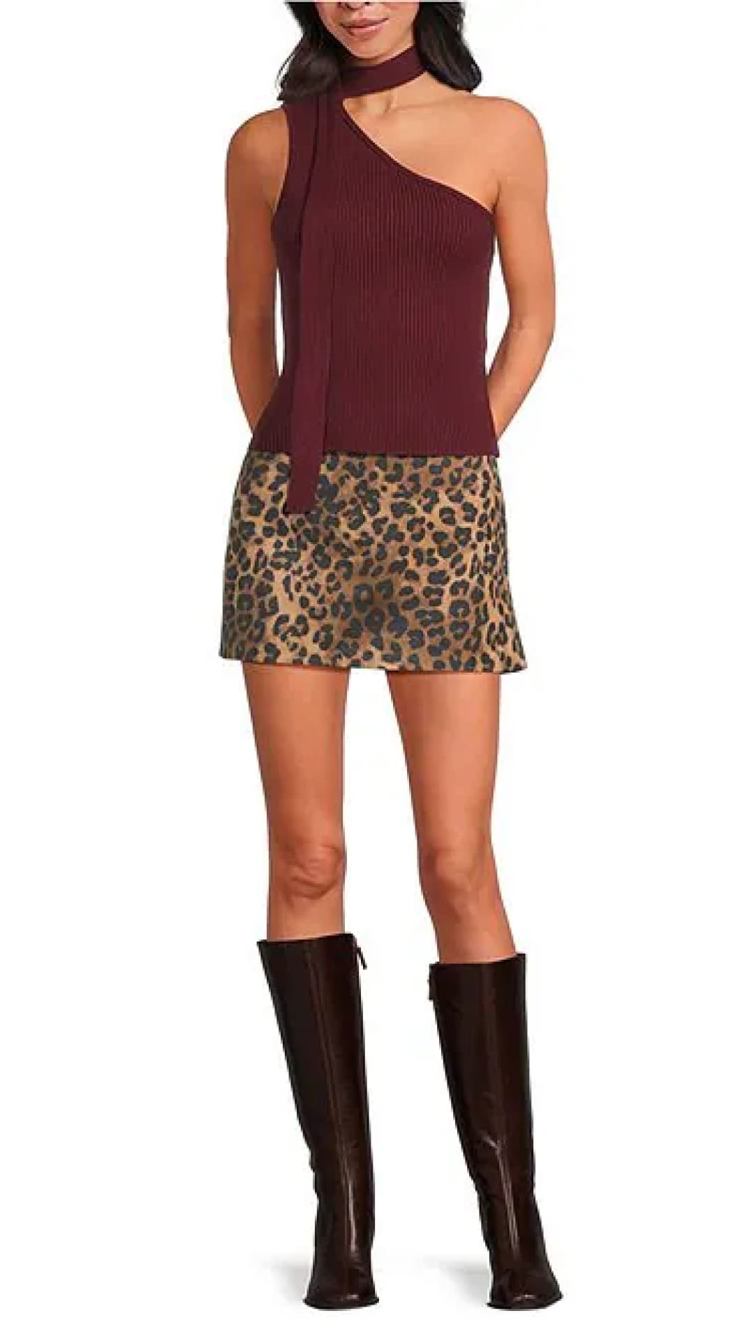 Women’s one-shoulder maroon top with a leopard print mini skirt and tall brown boots.