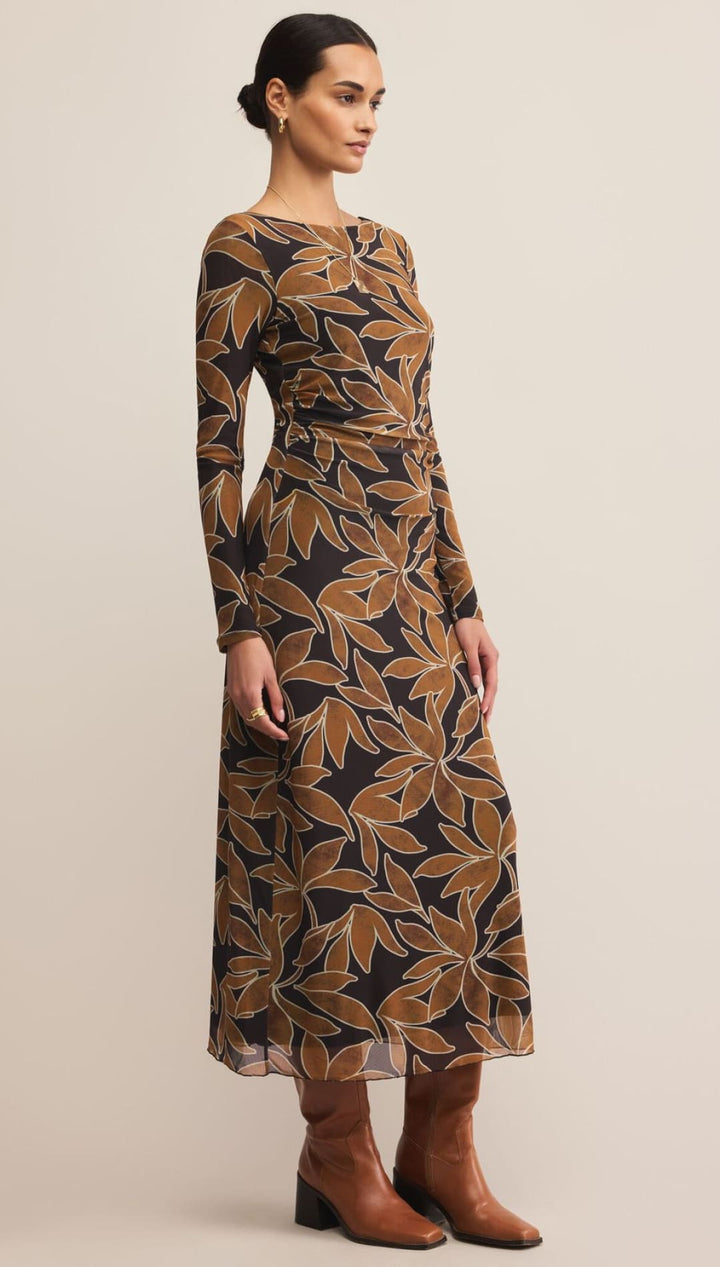 Brown and gold leaf print dress with long sleeves, made of sheer fabric.