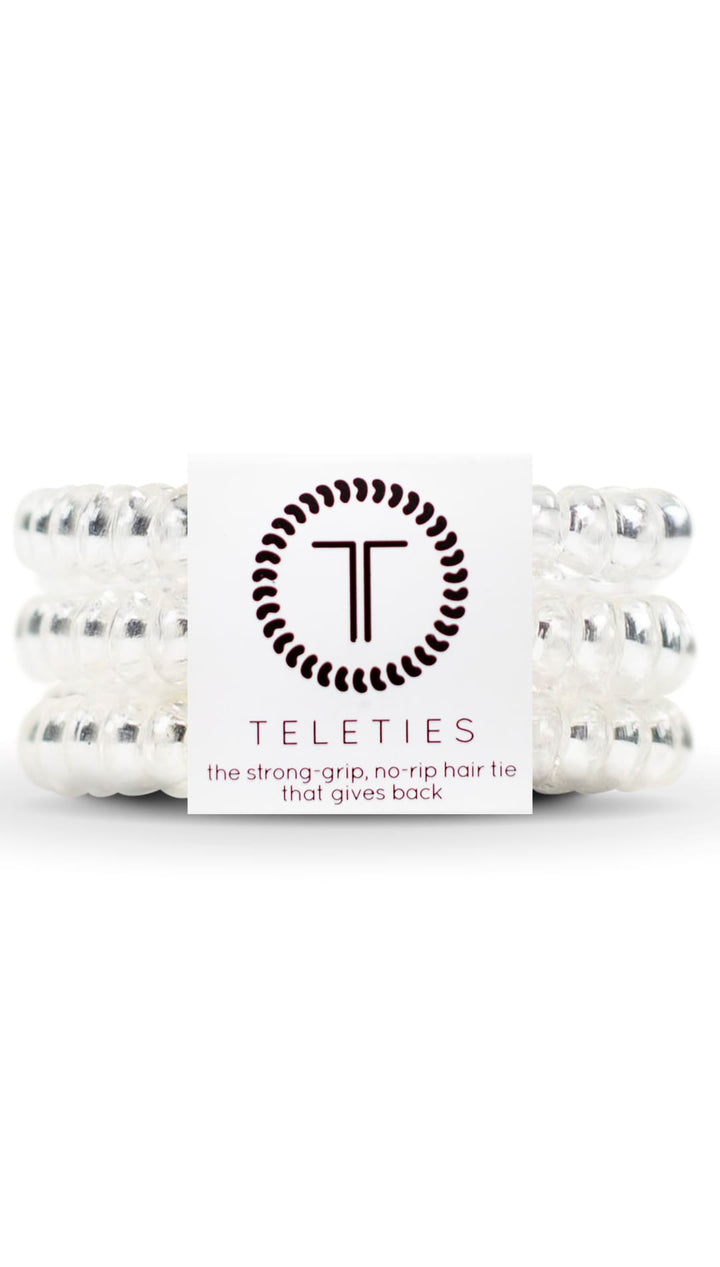 White teleties hair ties with black and silver accents, made of elastic material.
