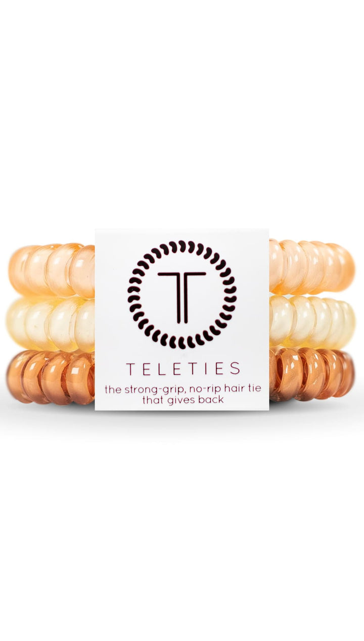 Orange and white spiral hair ties with a black logo.