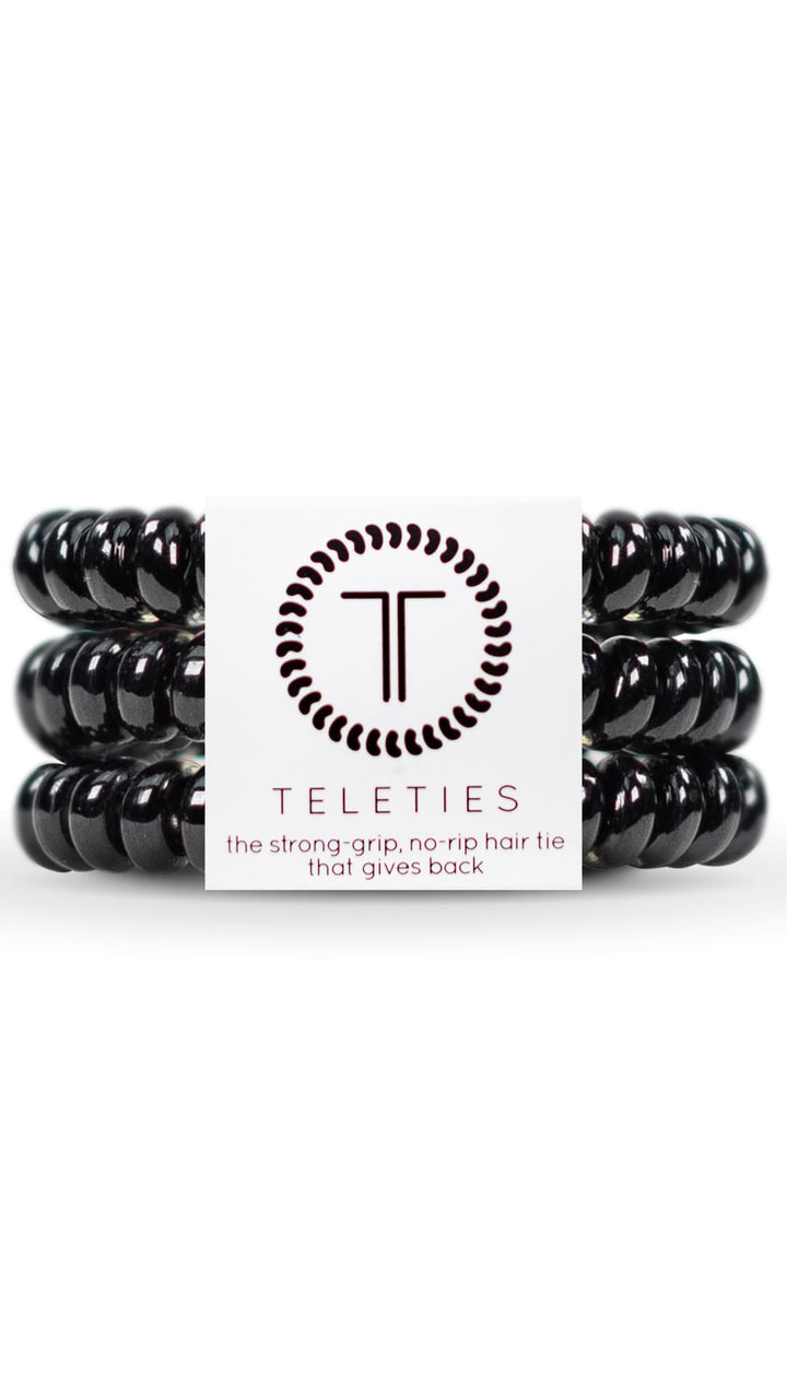 Black spiral hair ties with a circular logo featuring the letters ’tt’ in white and dark gray.