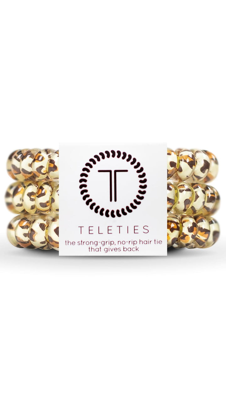 Gold and brown hair ties with a circular logo featuring the letters ’tt’ in black.