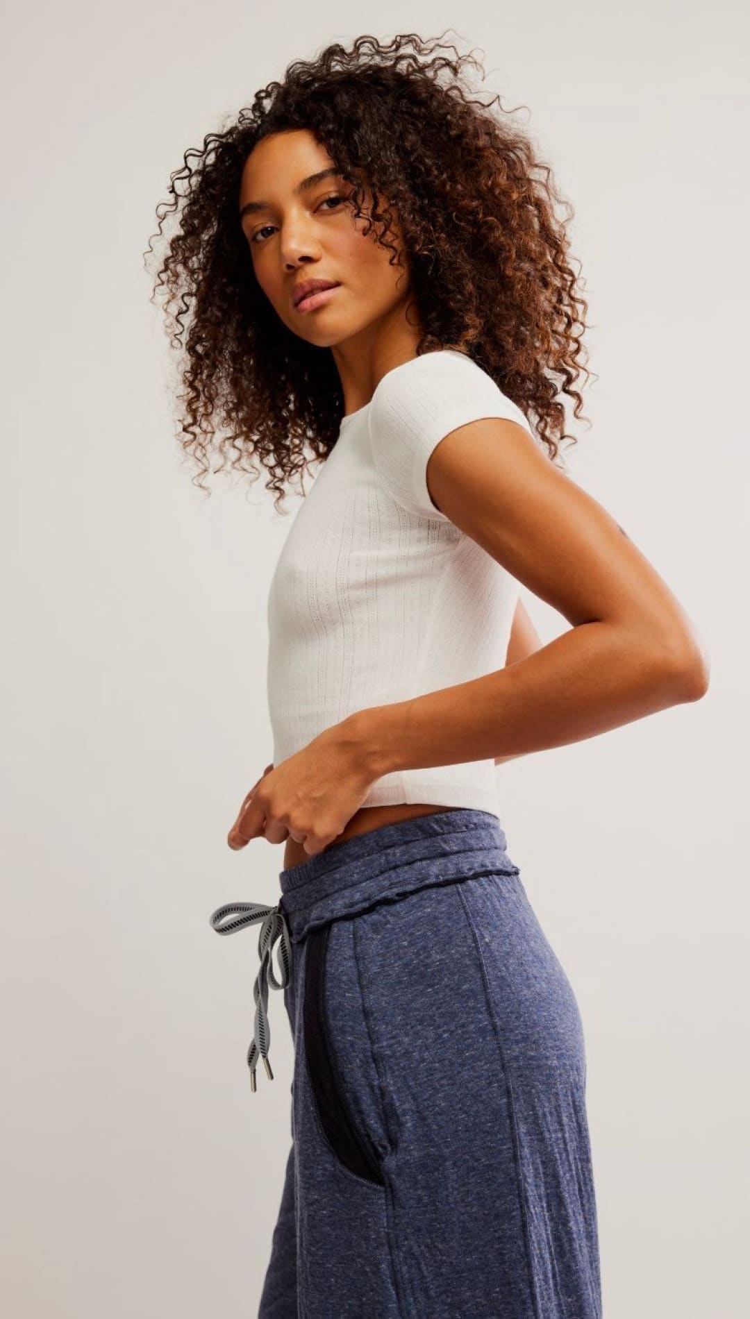 Woman in white top and blue pants.