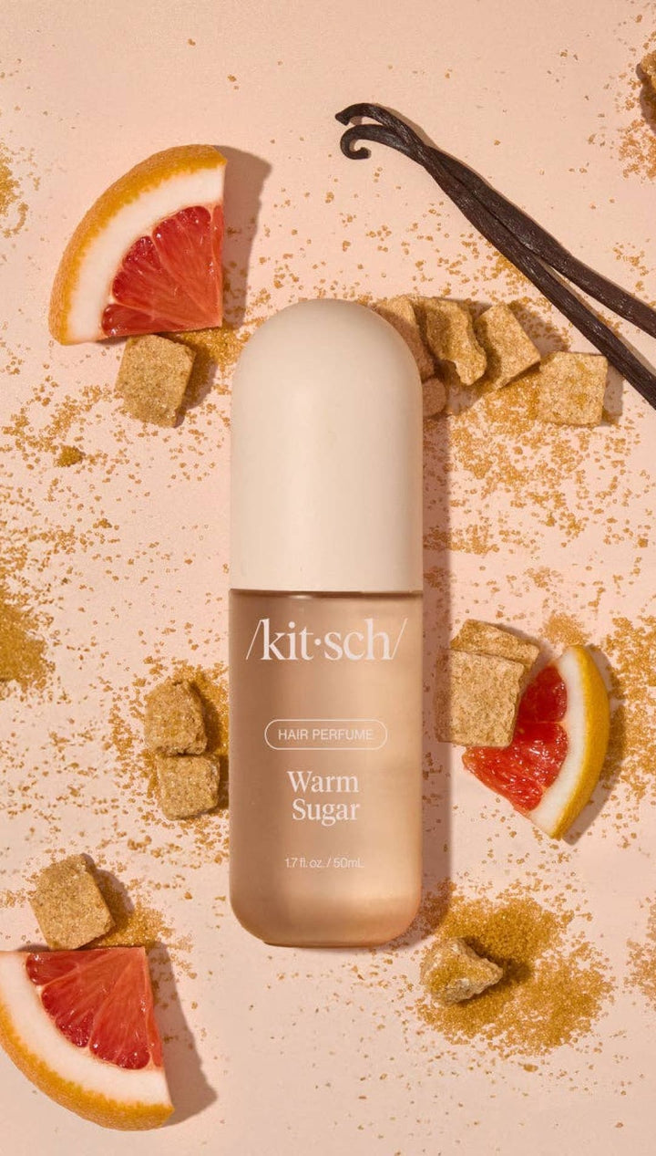 Warm sugar body wash bottle with vanilla pod and grapefruit slices.