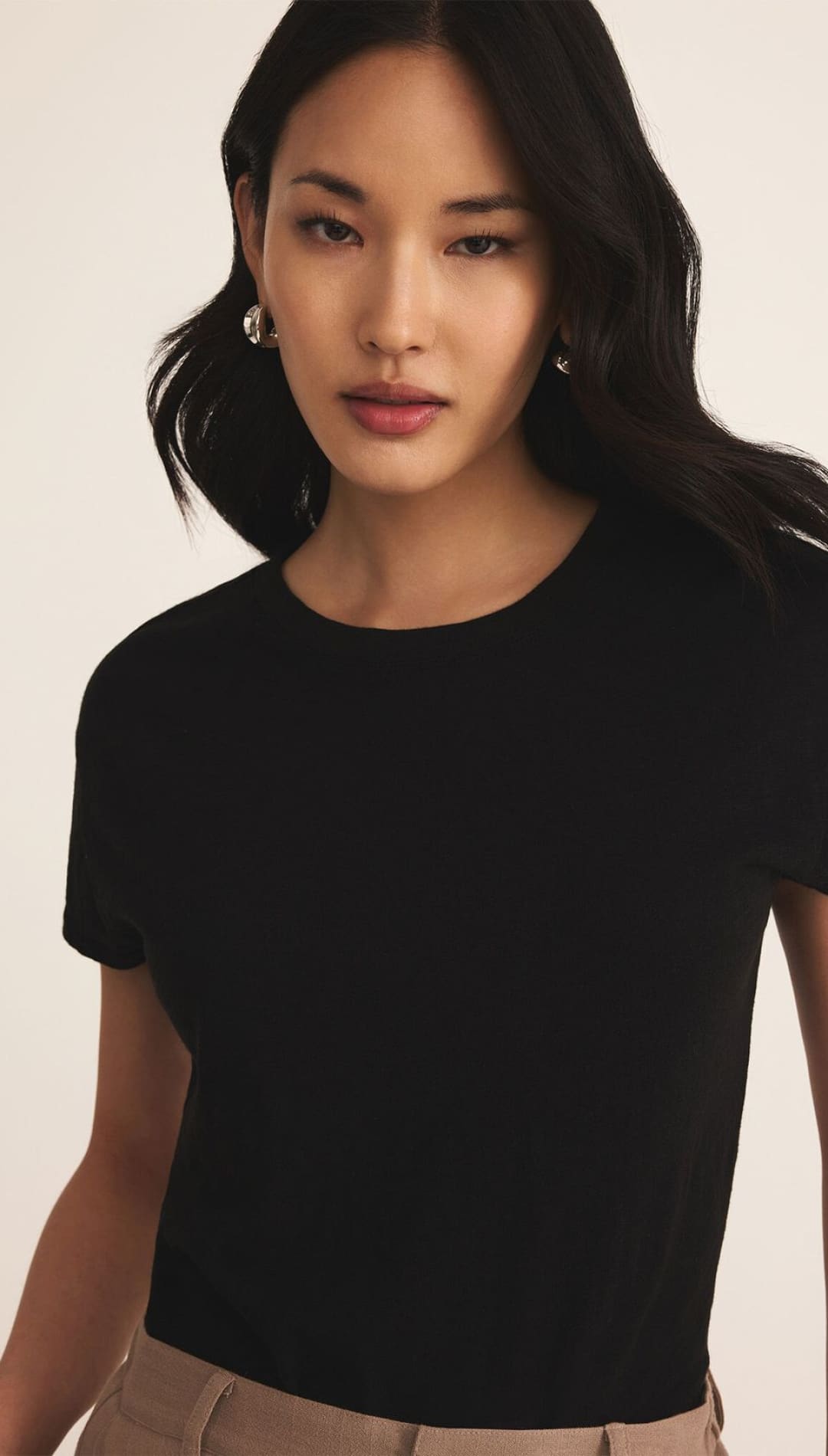 Black short-sleeved crop top with round neckline and subtle sheen.