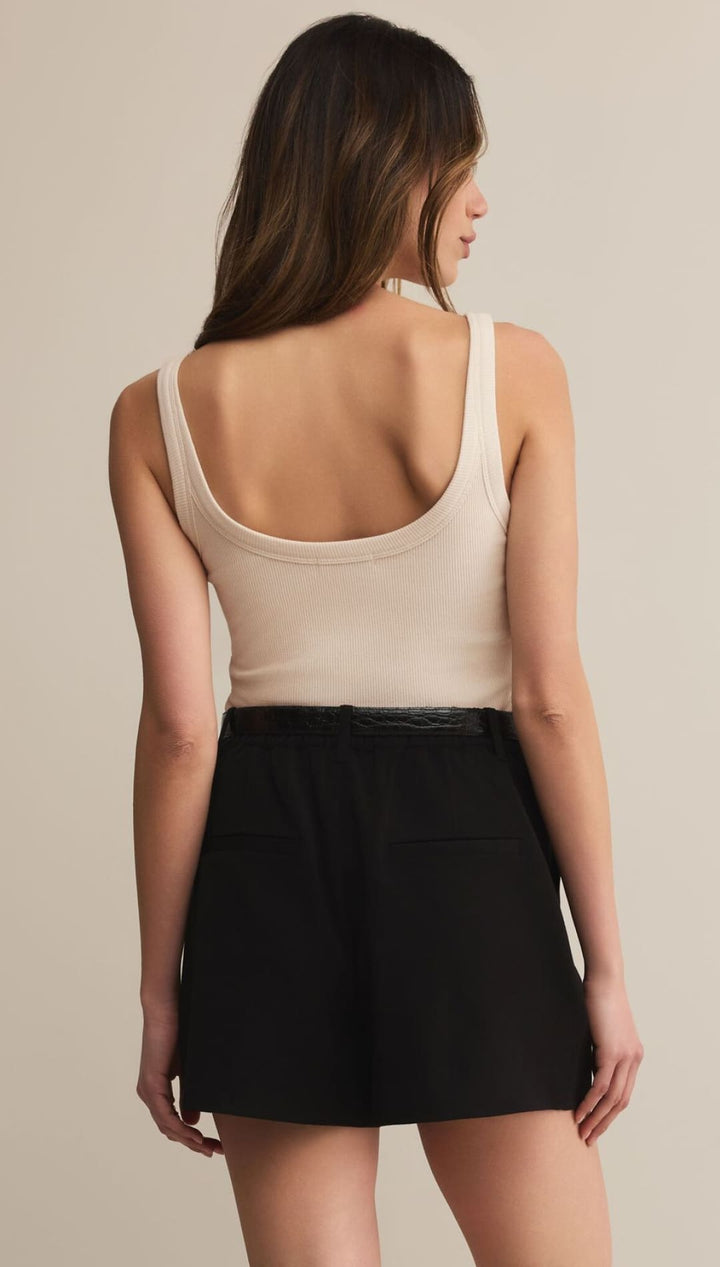 A woman’s beige tank top and black mini skirt.