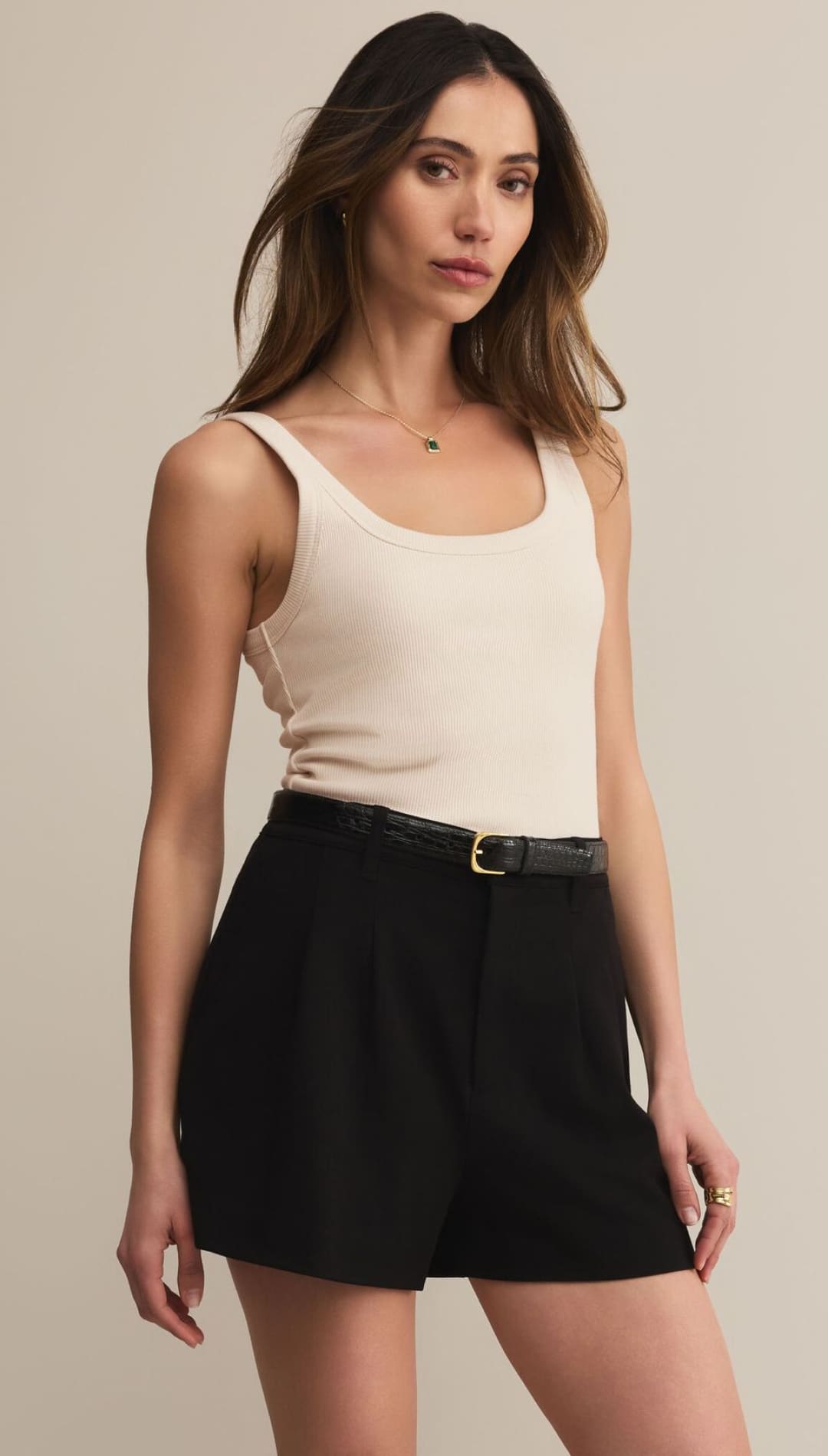 Women’s ribbed knit tank top and black tailored shorts with a belt.