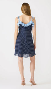 A navy blue polka dot dress with light blue ruffled shoulder ties and a sheer hem.
