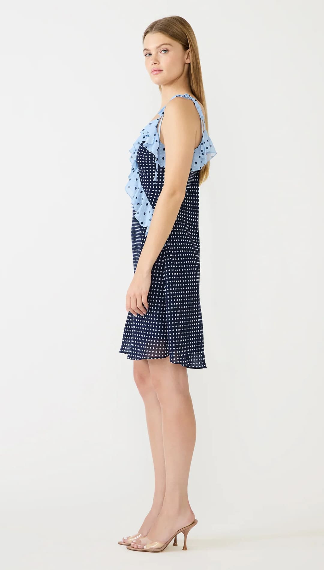 A navy blue polka dot dress with light blue ruffled shoulder accents.