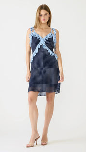 A navy blue polka dot dress with light blue sheer ruffled straps and a v-neckline.
