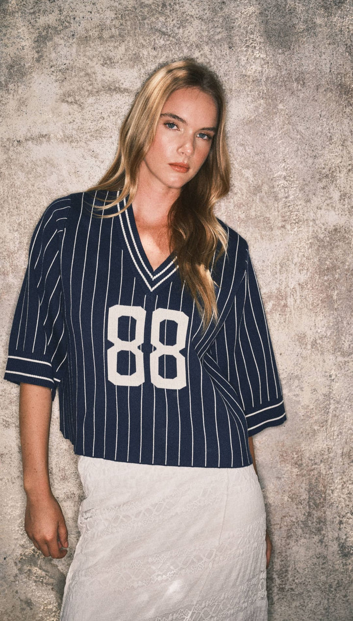 Navy pinstripe baseball jersey with white number 88 and lace skirt.