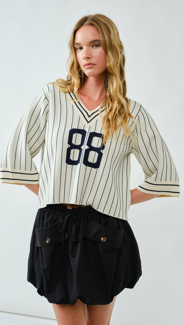 Striped baseball jersey with the number 86 in navy blue on a white background, made of cotton and polyester blend.