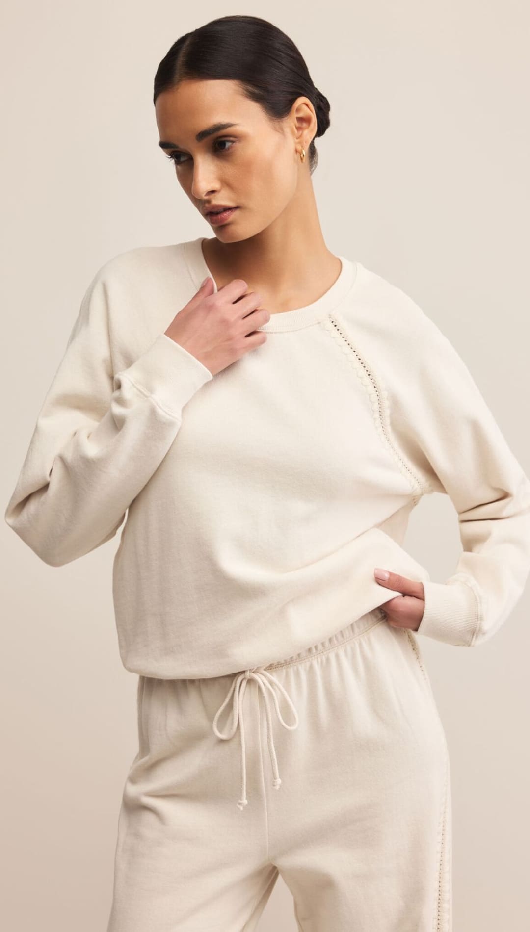 Cream cashmere sweater with drawstring waist and ribbed cuffs, neckline, and hem.