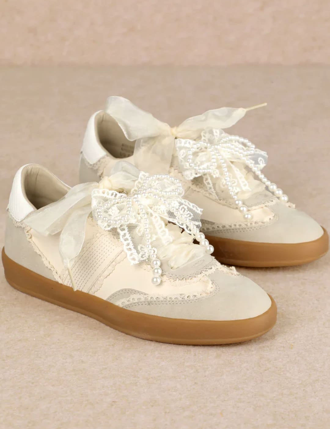 White lace sneakers with gum soles and laces.