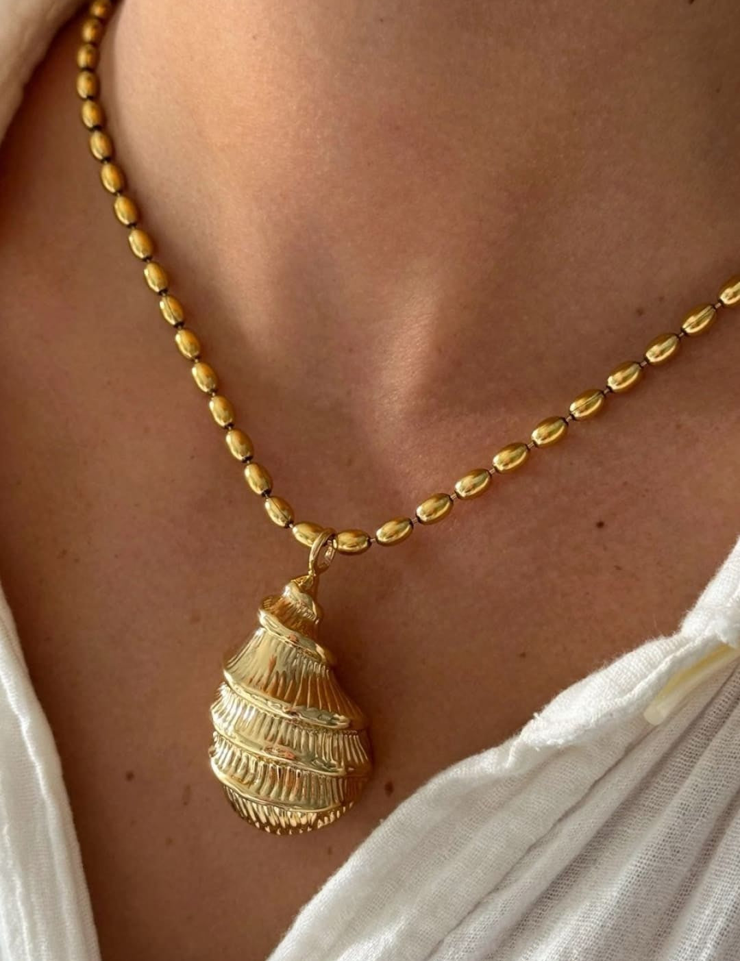 Gold shell pendant necklace.