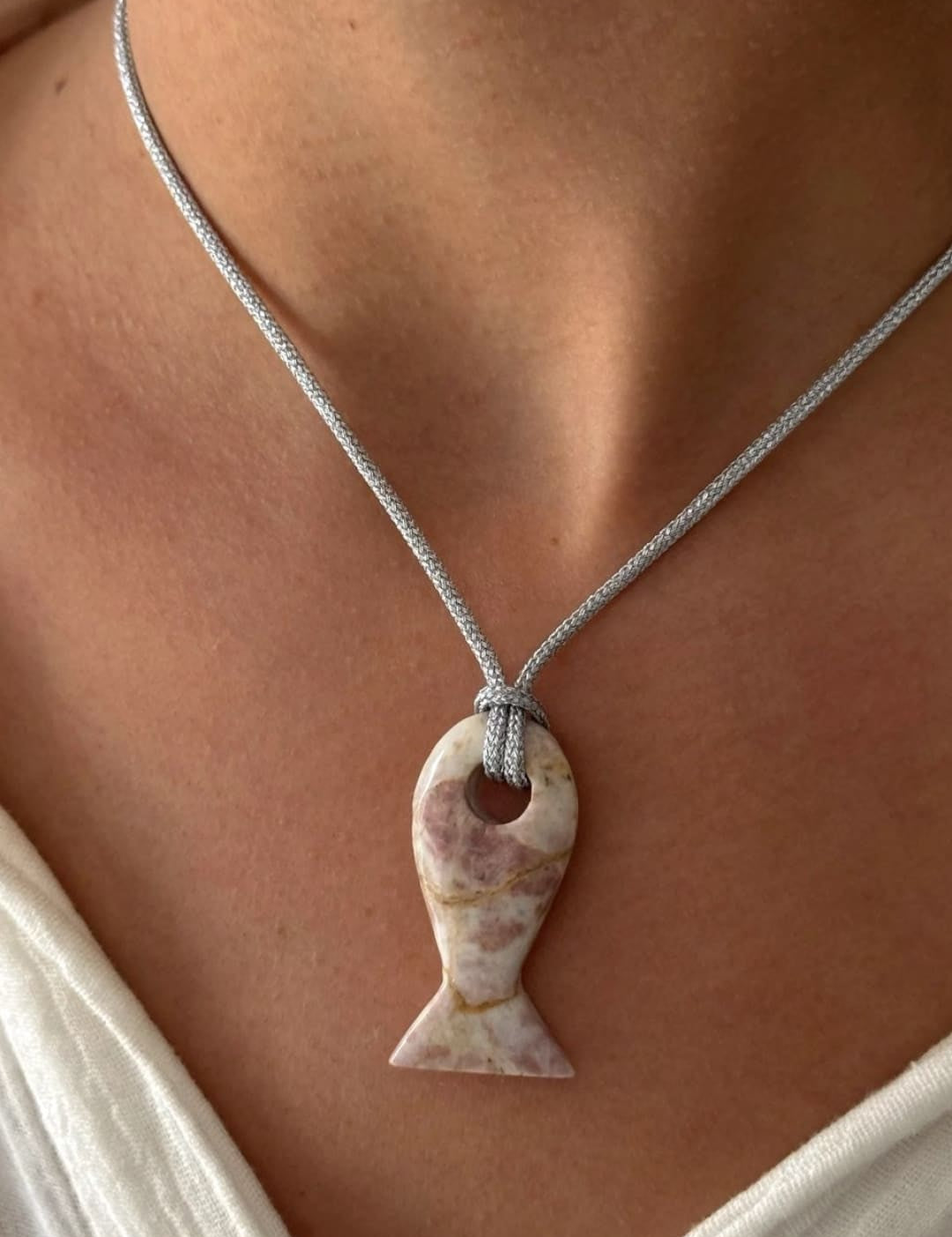 Fish-shaped stone pendant necklace.