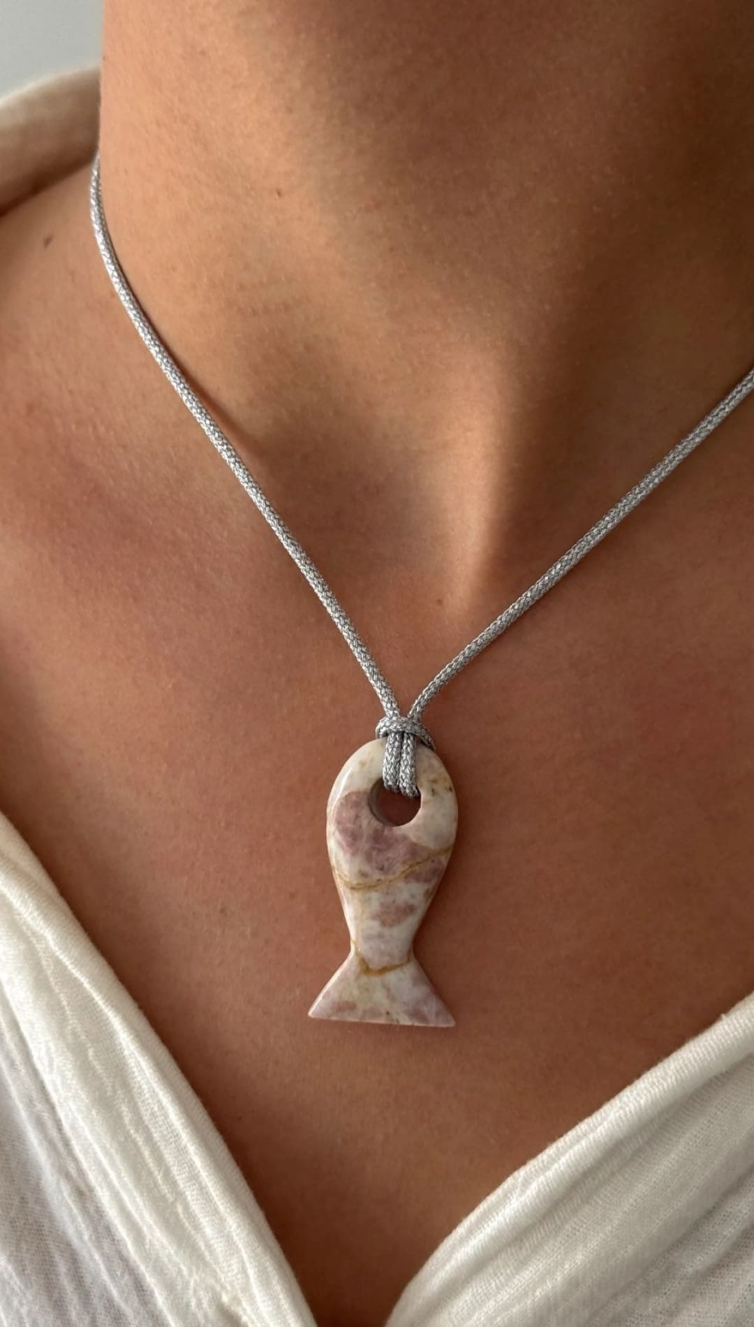 Fish-shaped stone pendant necklace.
