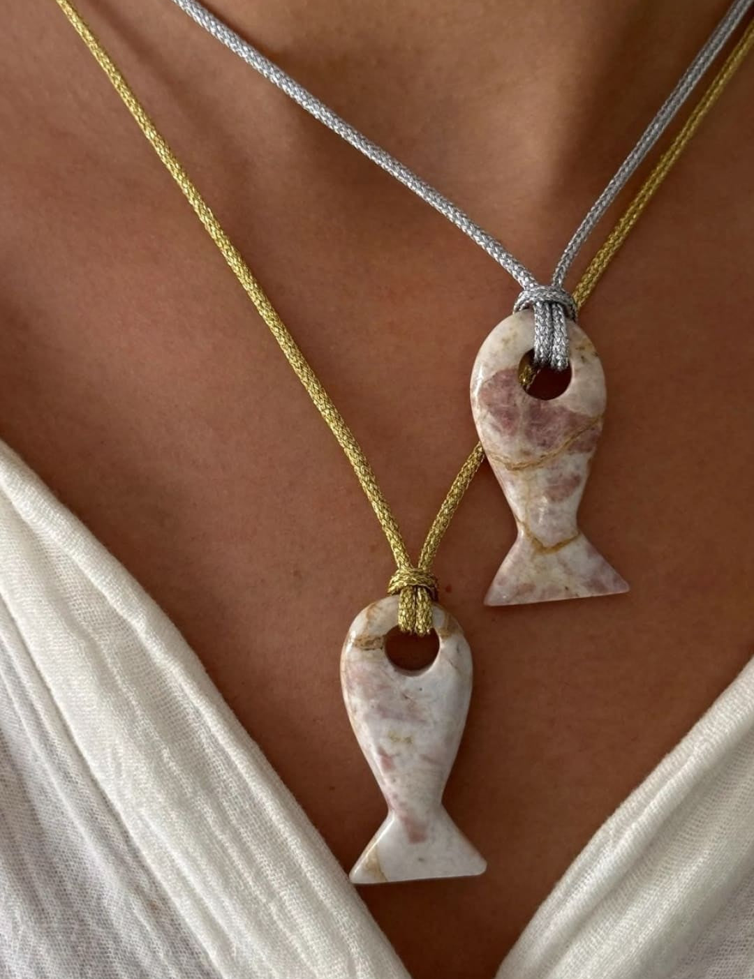 Two fish-shaped pendants on cords.
